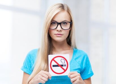 fille tenant une pancarte interdiction de fumer dans l'entrée